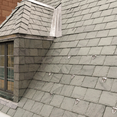 Natrual slate roof with color-matched, powder-coated, pad-style snow guards.