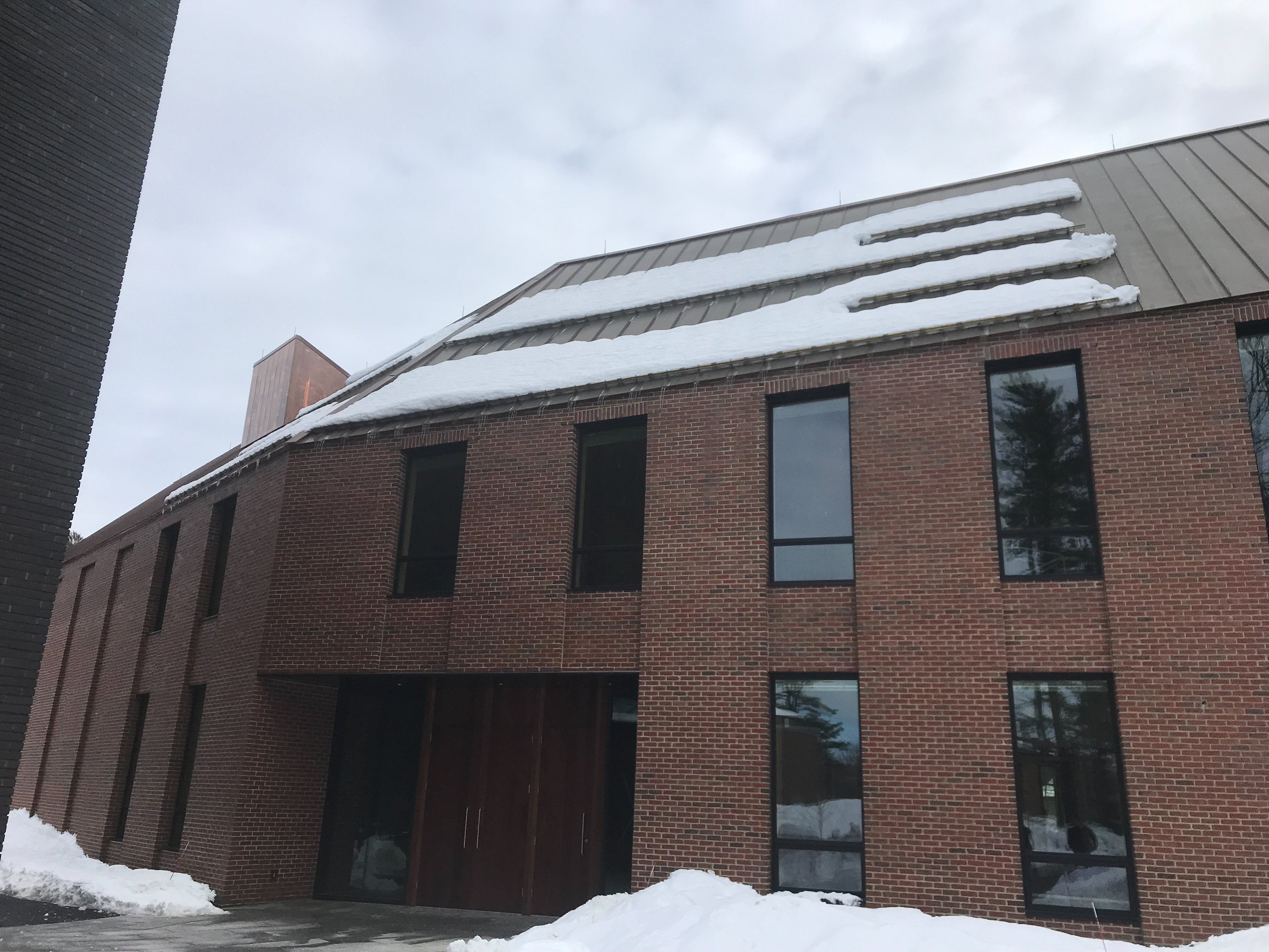 Standing seam mental room on commercial property using customized clamps and fence-style snow retention system.