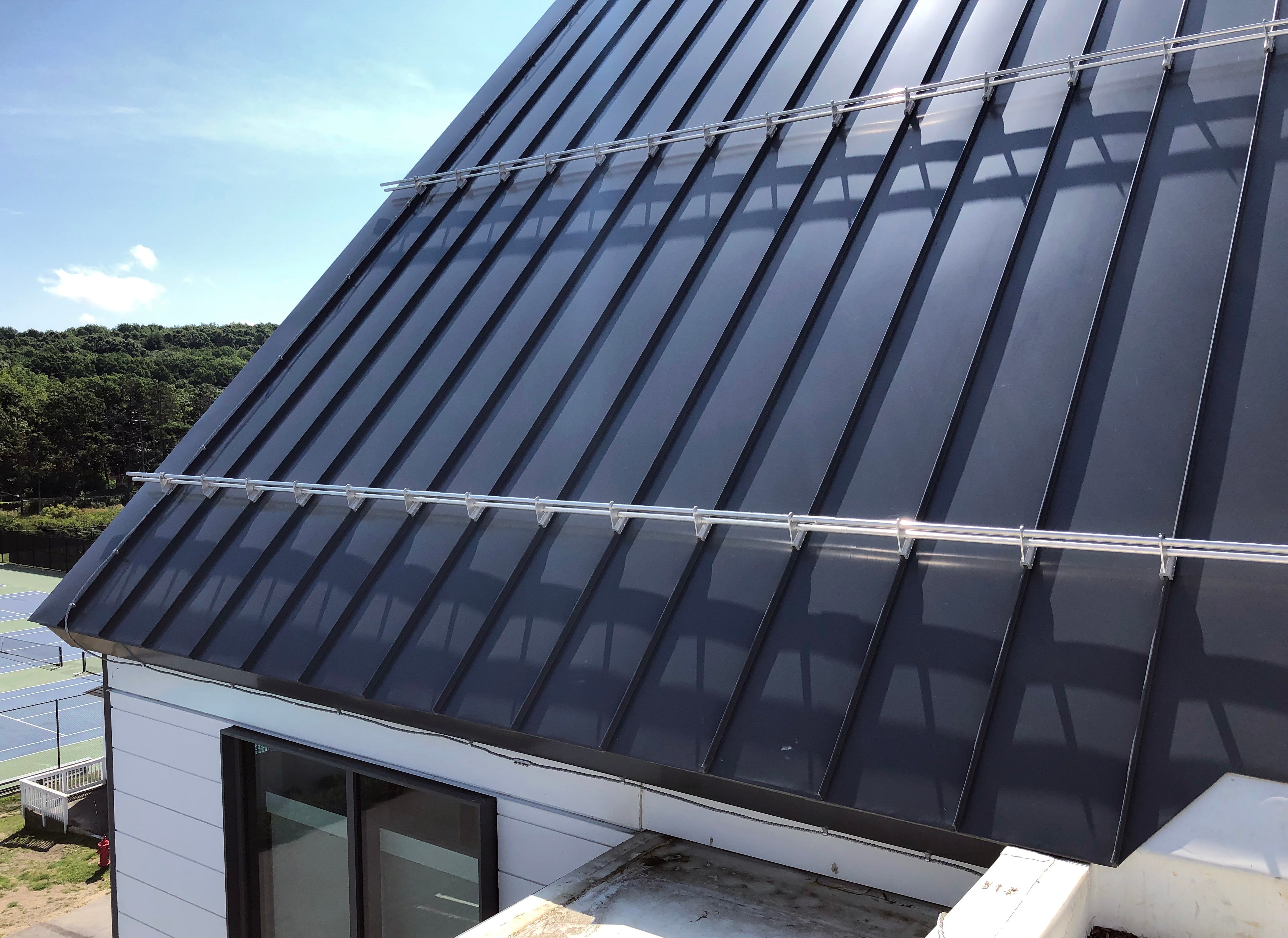Brooks School in North Andover Massachusetts. Commercial property with standing seam metal roof and custom snow retention system using pipe style snow guards.
