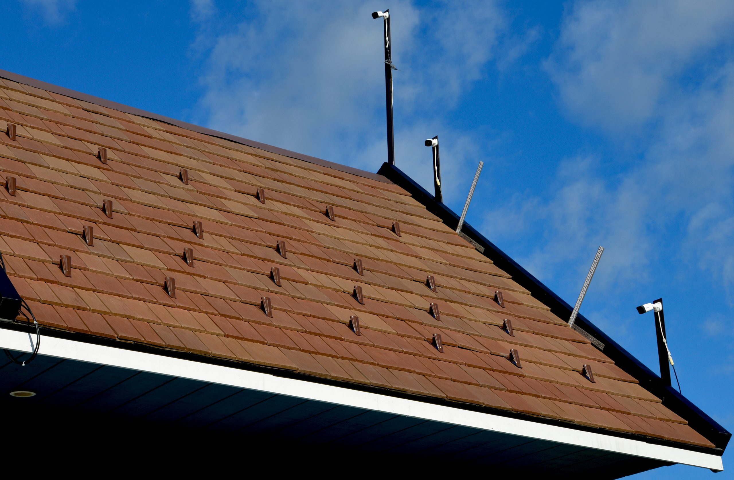 Poweder coated fusion-guard snow retention system on multi-width composite shingle roof.