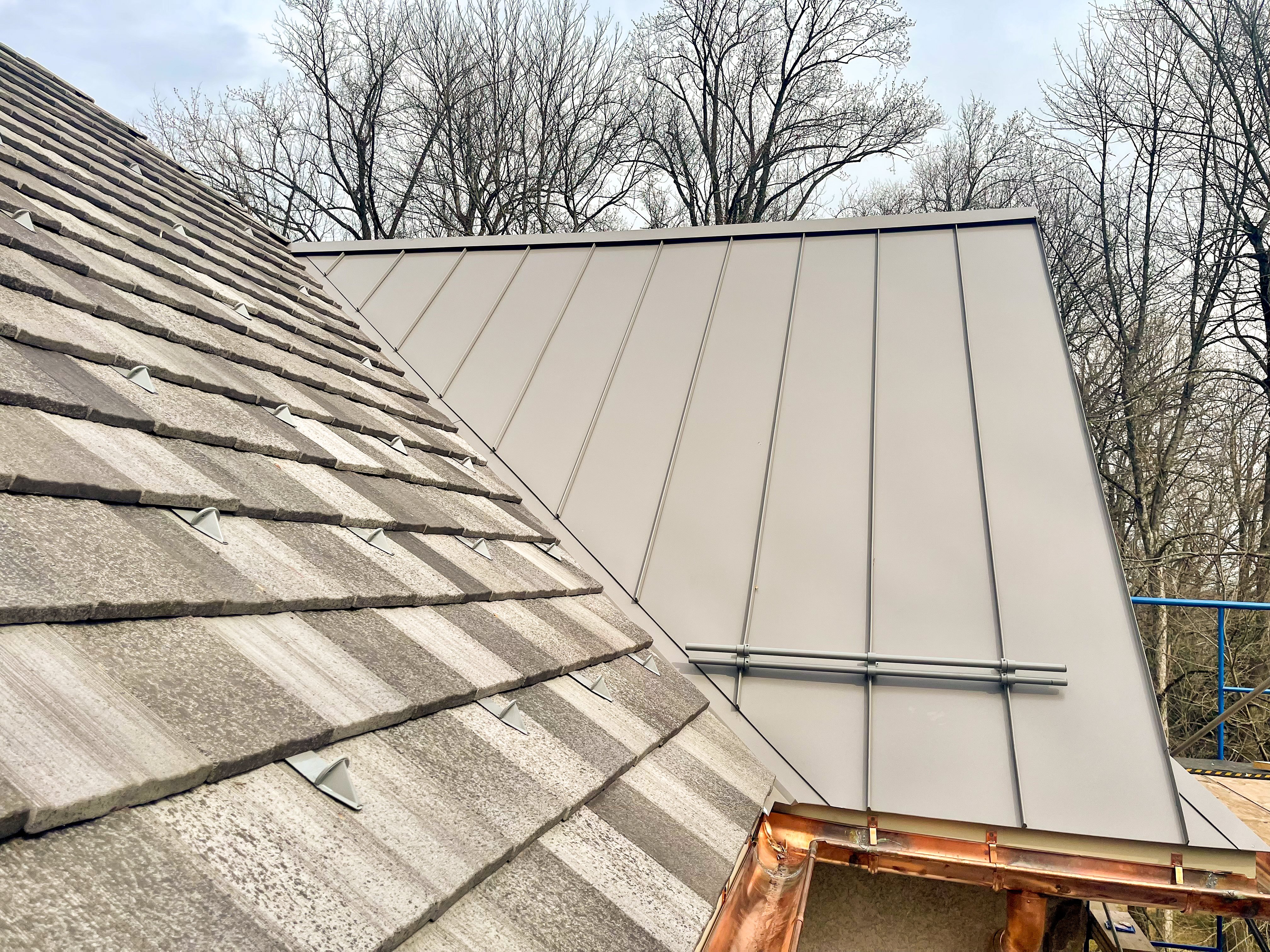 Custom pad and pipe style snow retention system for combination metal and asphalt shingle on residential roof.