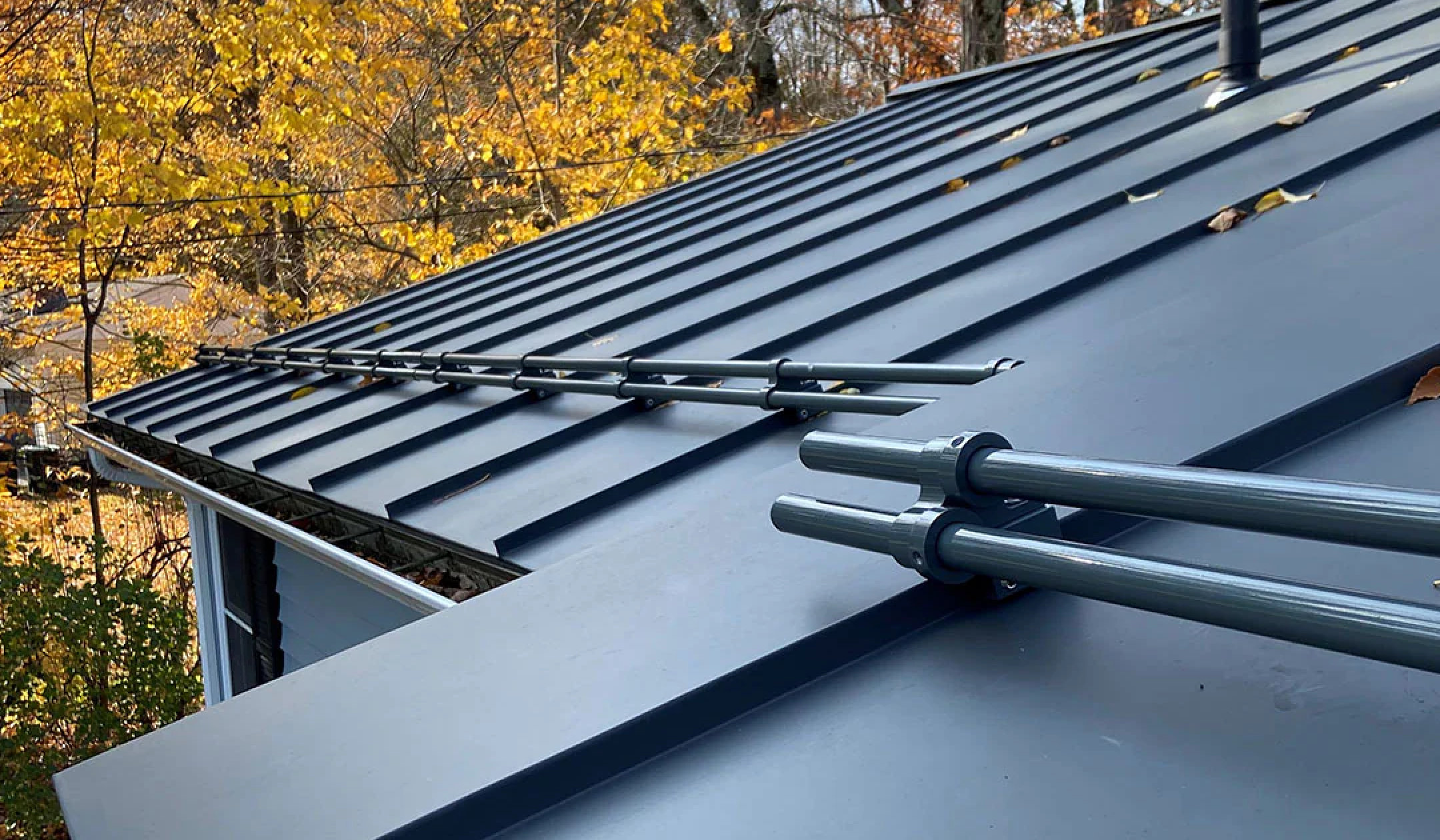 Pipe-style snow guards on a standing seam metal roof.